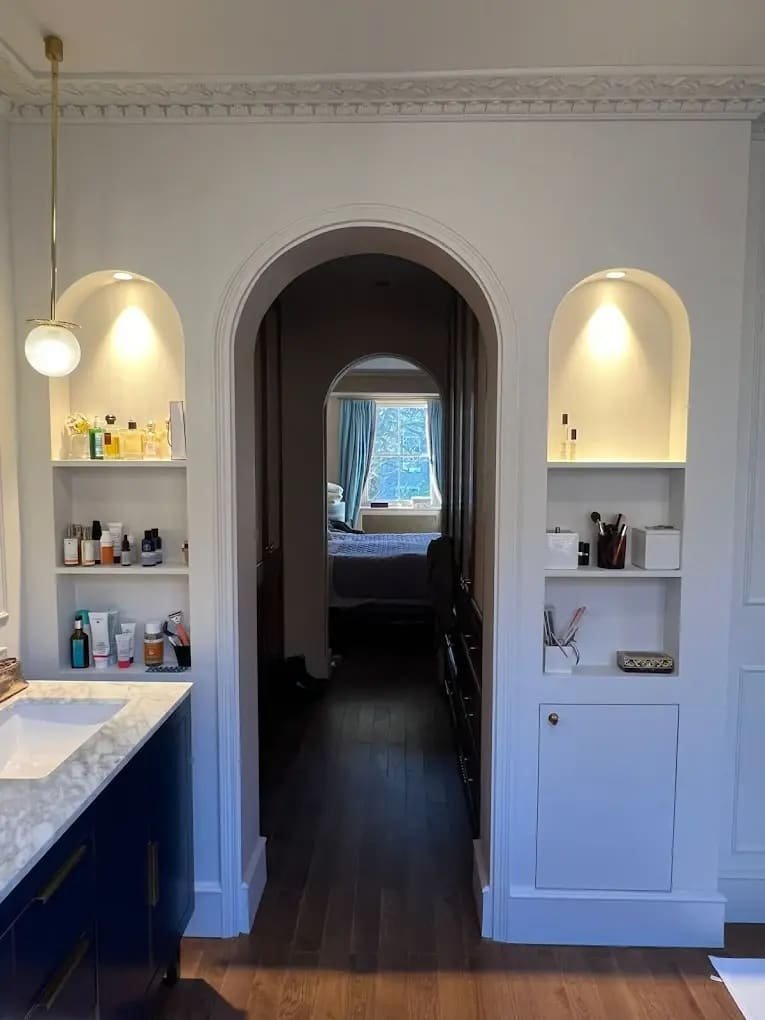 Luxury beverly hills home remodeling featuring arched hallway entry, custom built-in shelving, marble vanity, and modern bathroom design